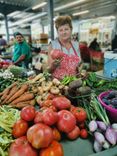 Woman at the market stall with different vegetables.