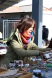 Andrea la taraba ei de pe piață, prezentând diverse obiecte în borcane.